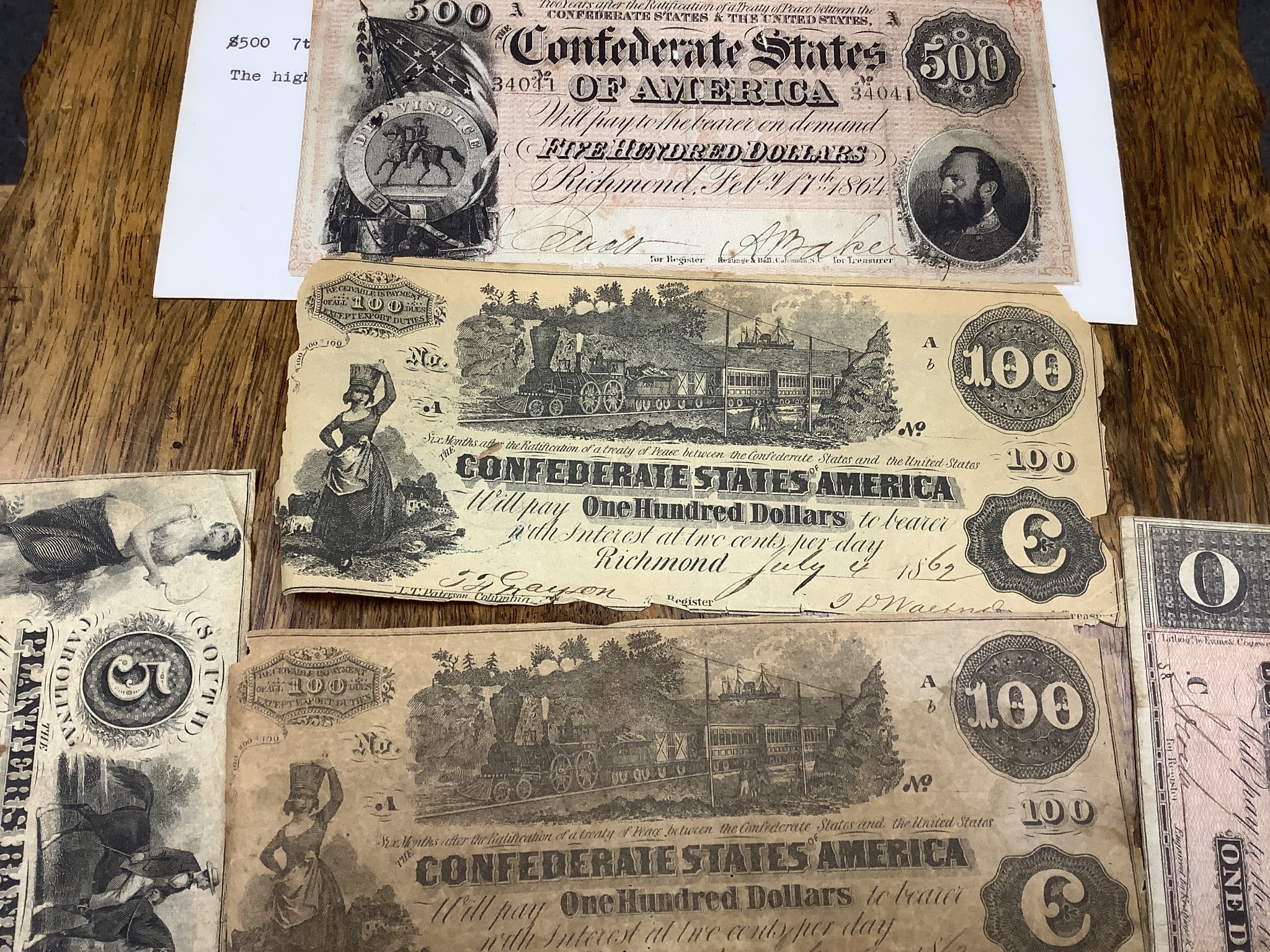 A collection of US Confederate States banknotes, including a confederate states of America $500 seventh issue 17 February 1864, $100 Richmond July 4 1862 x 2 and another 1864, and many others